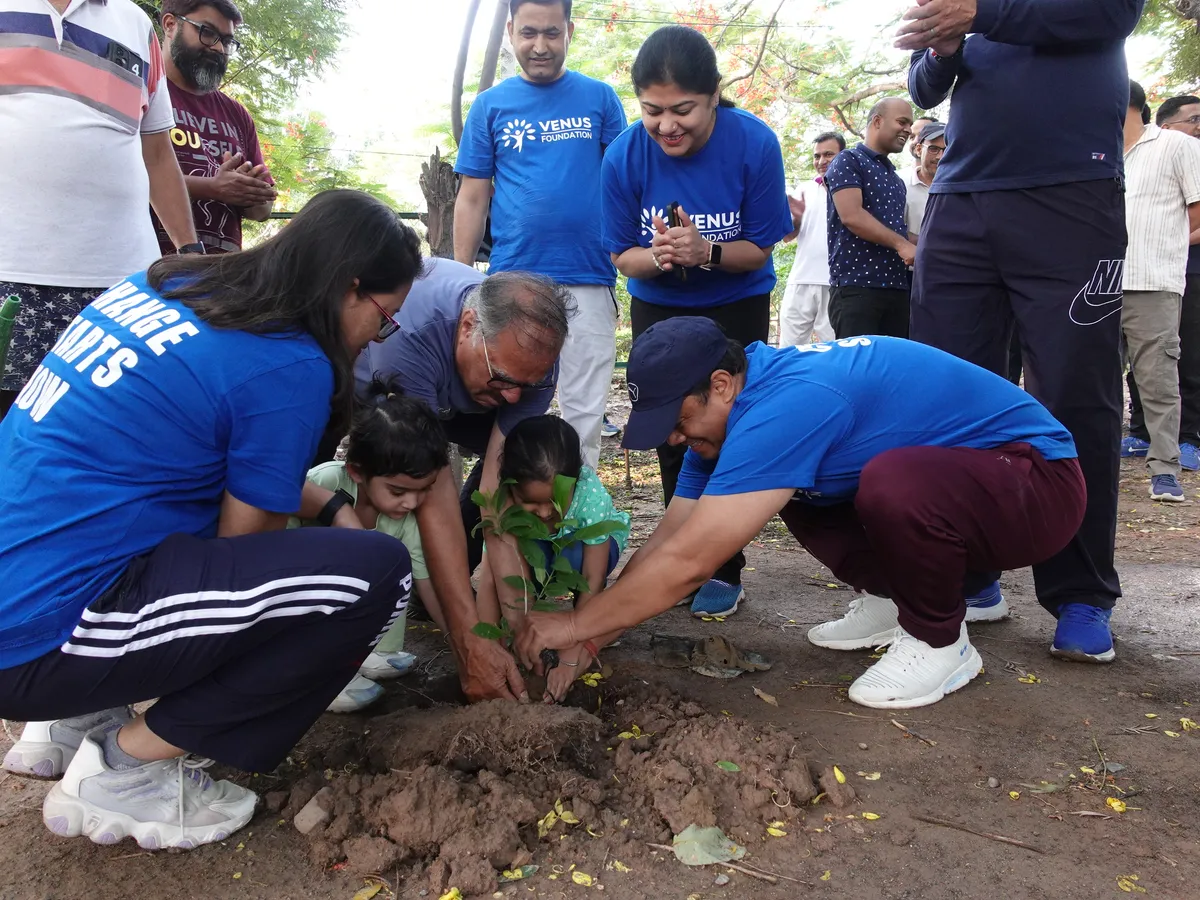 Volunteers and children planting a sapling